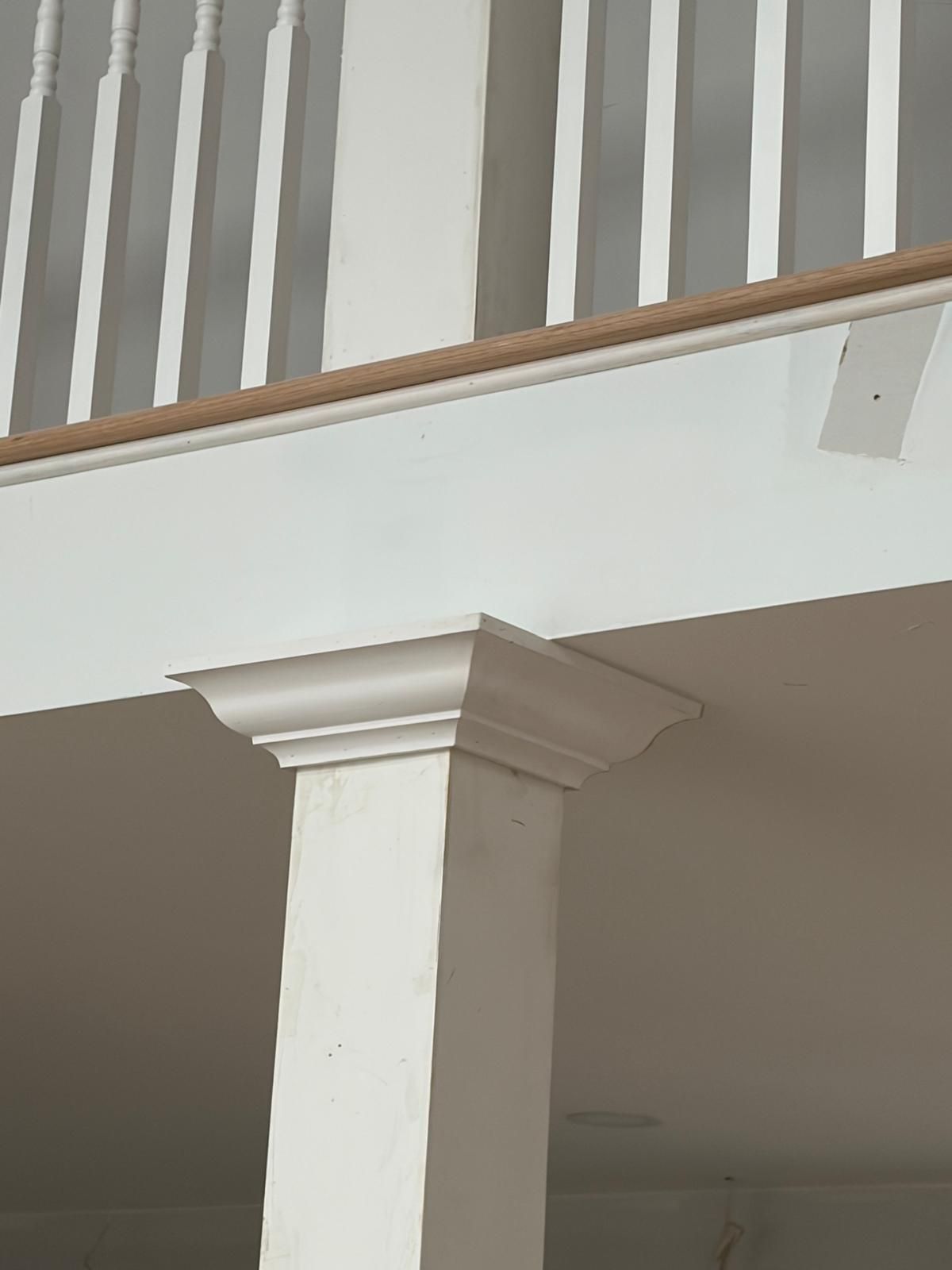 White column supporting a balcony railing in an indoor stairwell