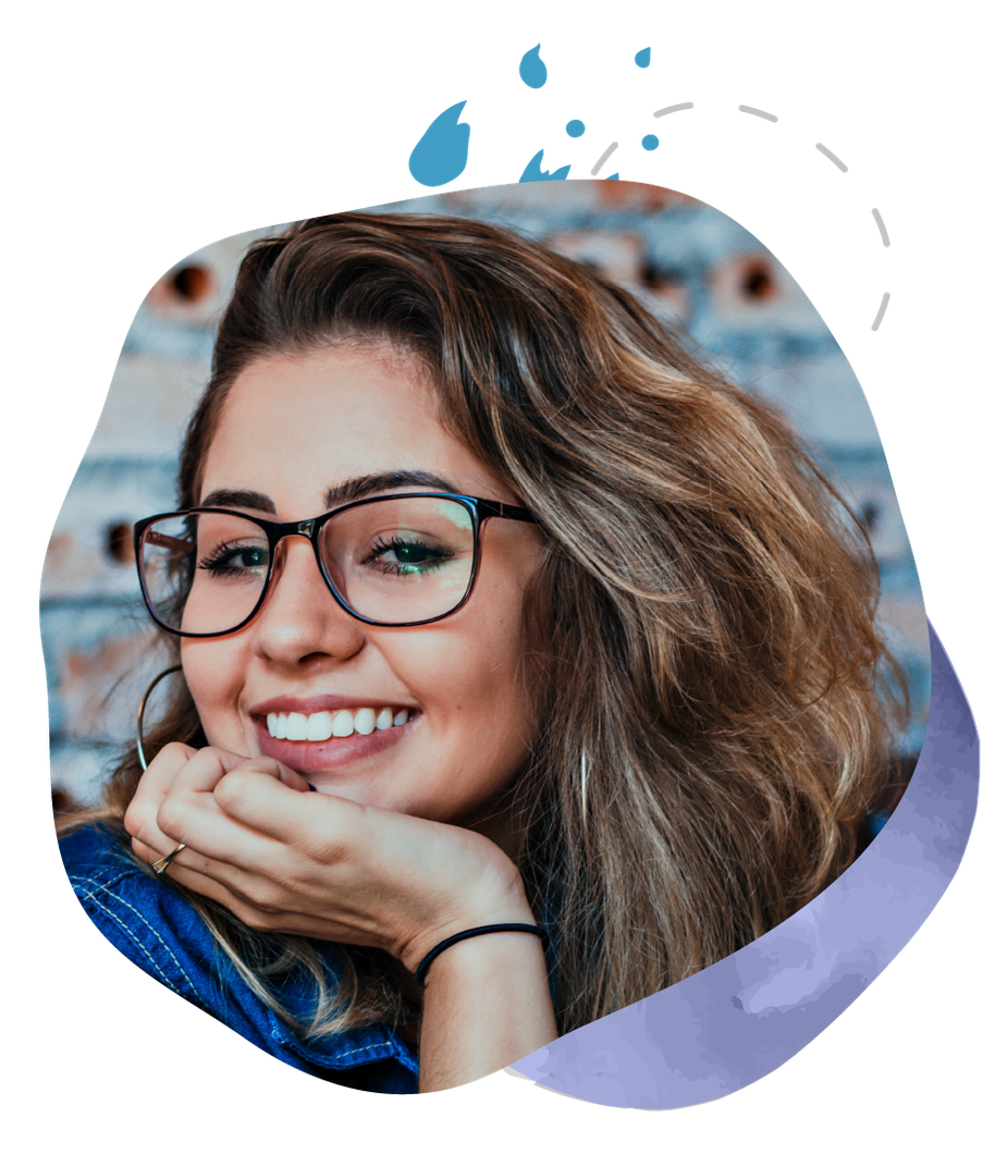 A woman wearing glasses is smiling with her hand on her chin.
