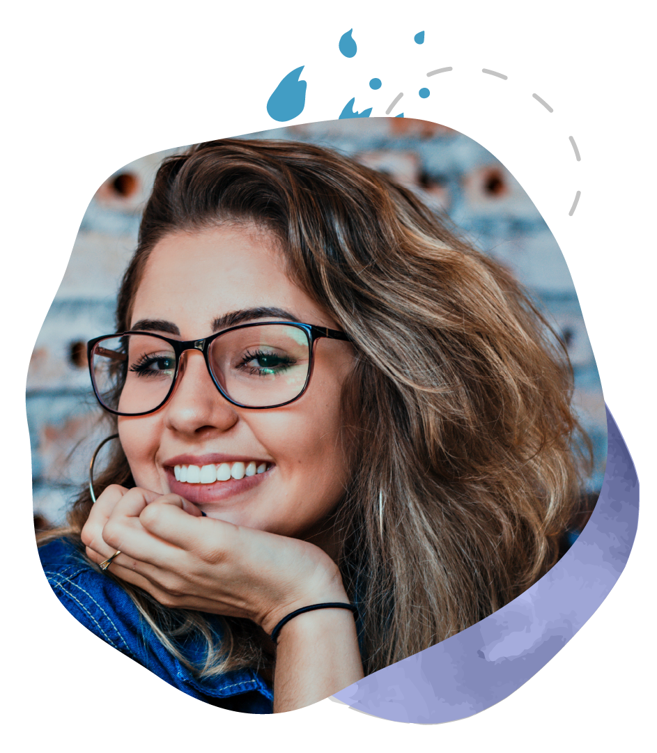 A woman wearing glasses is smiling with her hand on her chin.