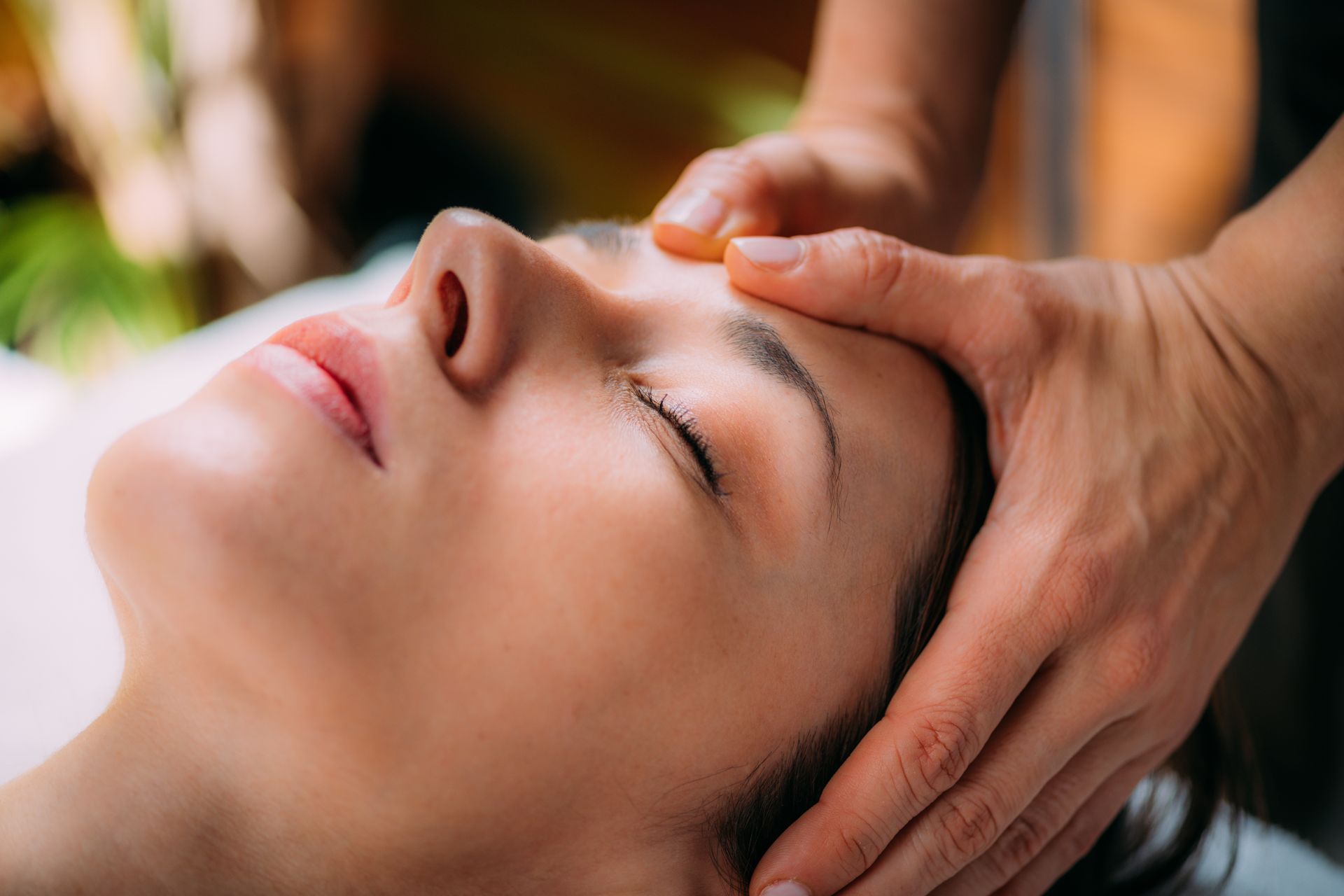 A woman is getting a head massage at a spa.