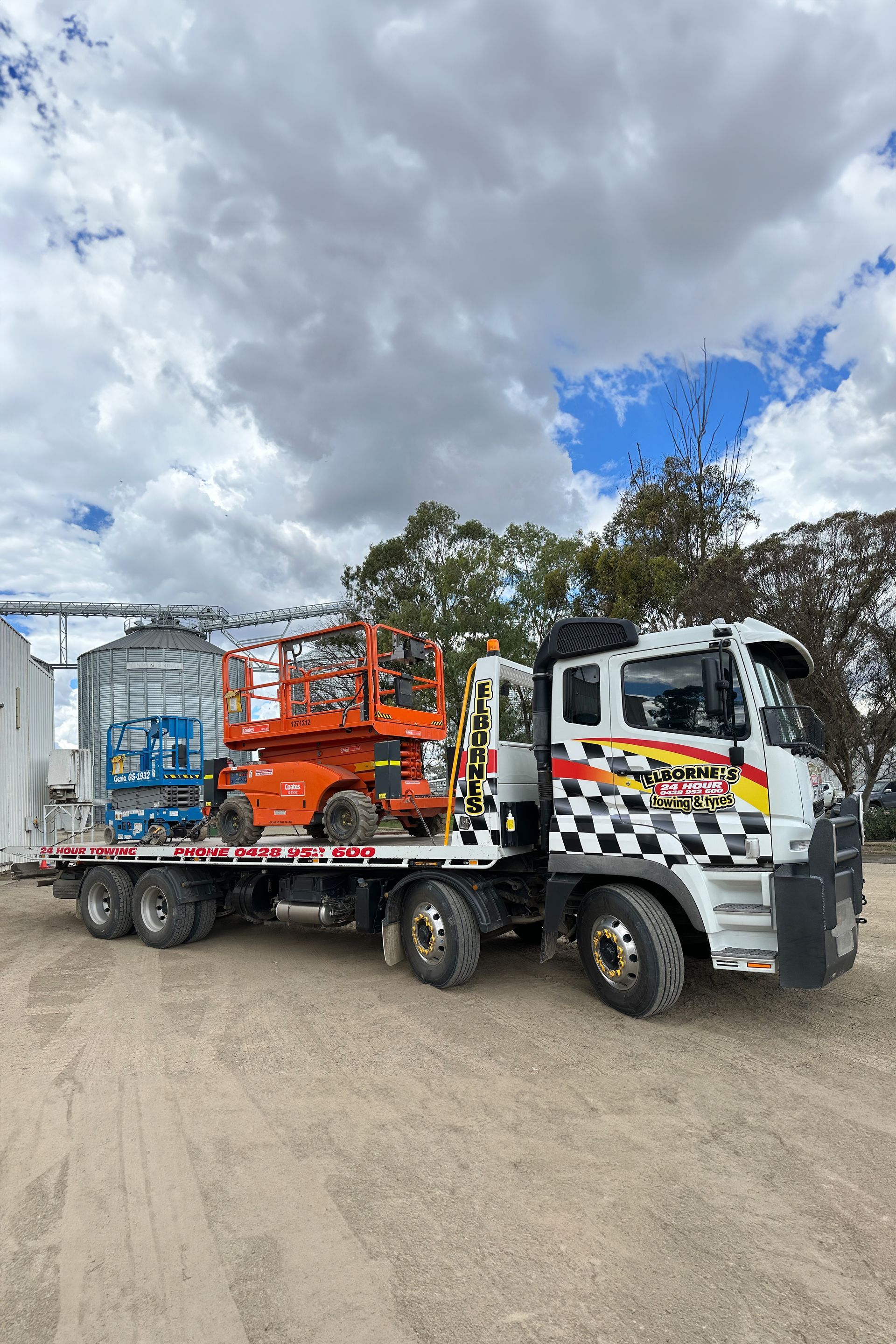 A tow truck is carrying a lift on the back of it.