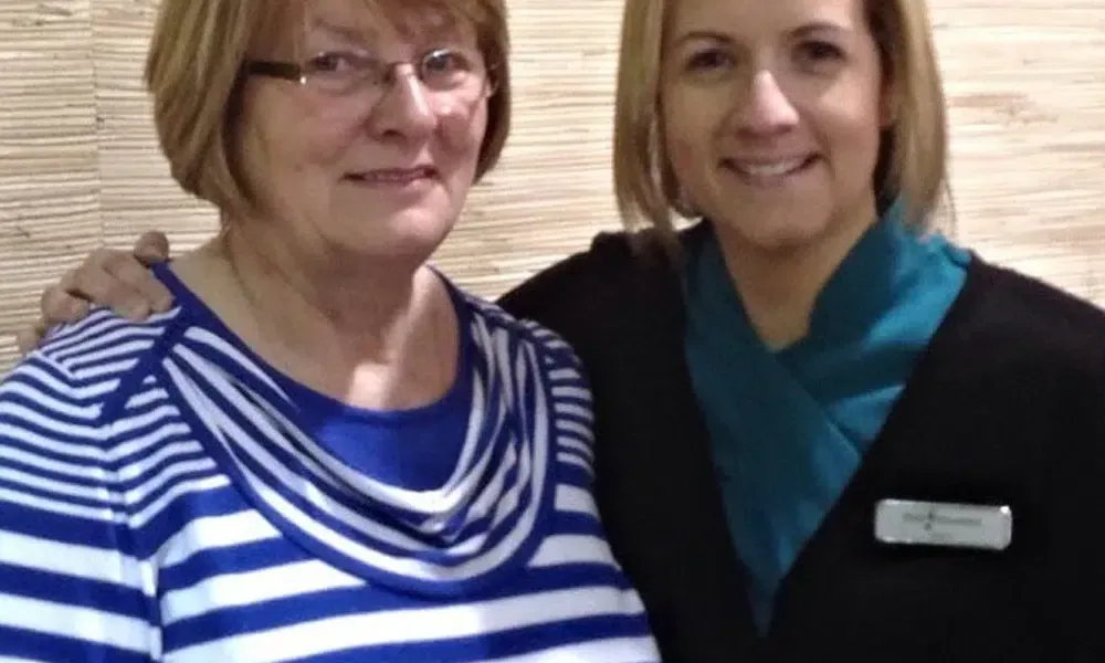 Two women are posing for a picture together and one of them is wearing glasses.