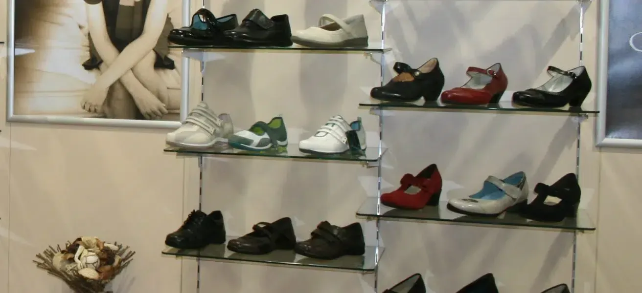 A display of shoes in a store with a picture of a woman behind them
