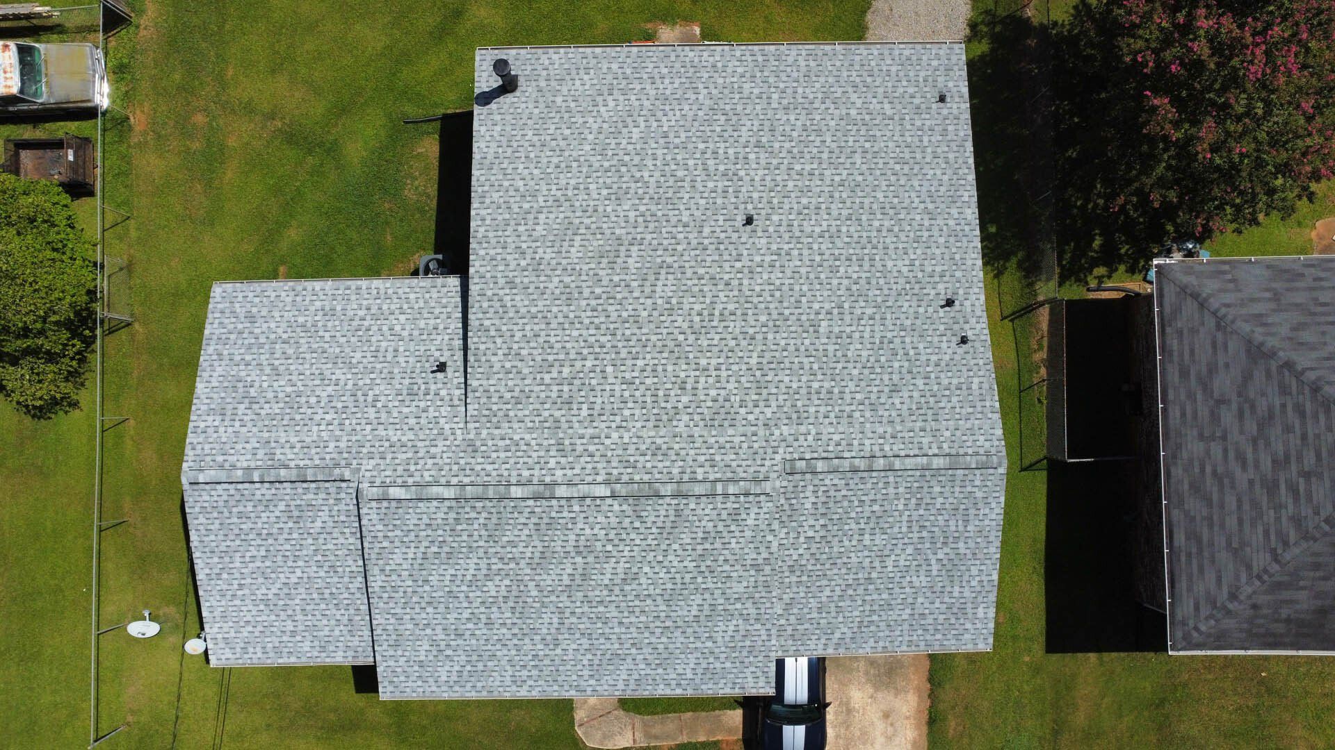 An aerial view of a house with a roof that is covered in shingles.