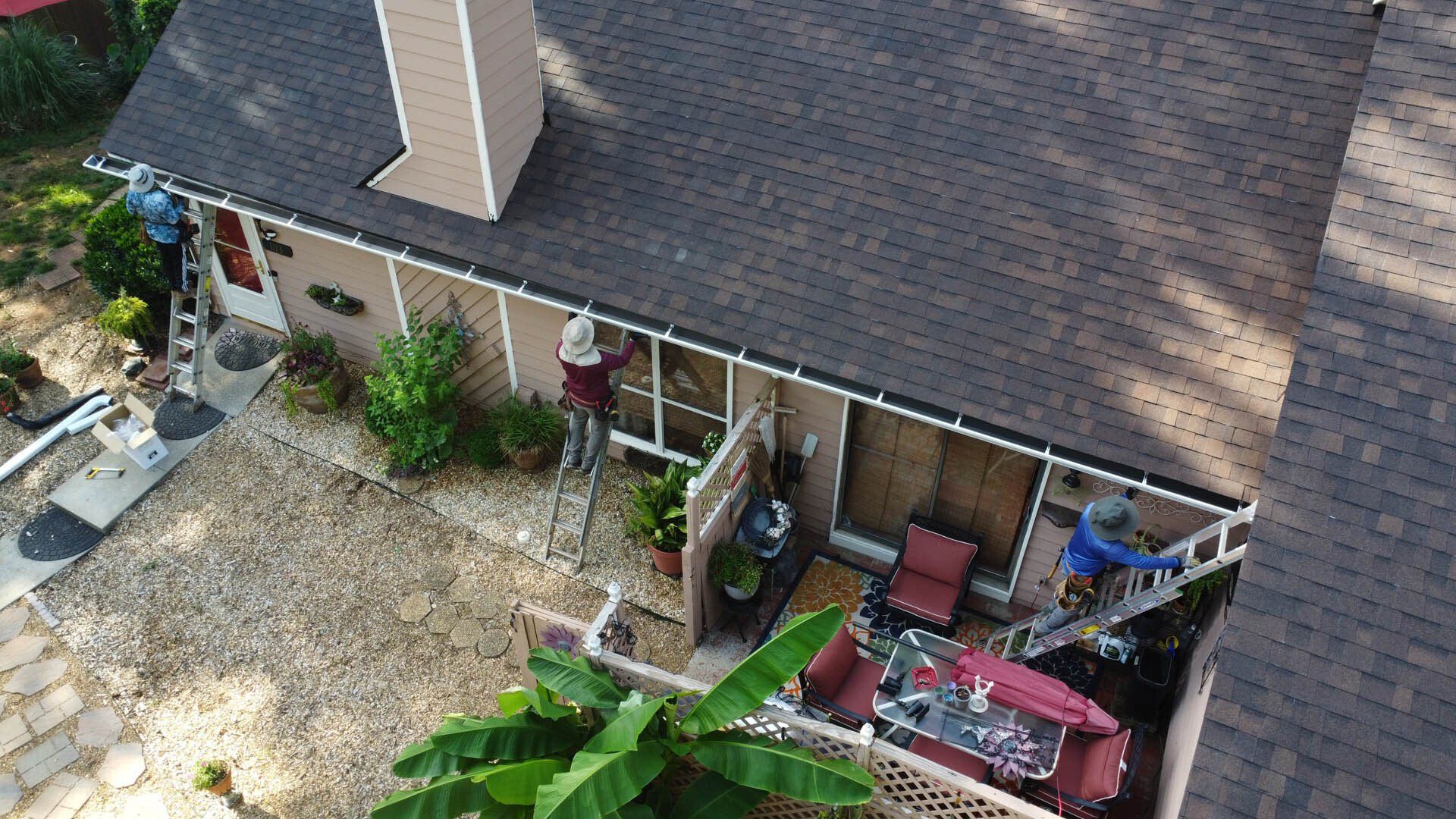 An aerial view of a house with a roof that is being painted.