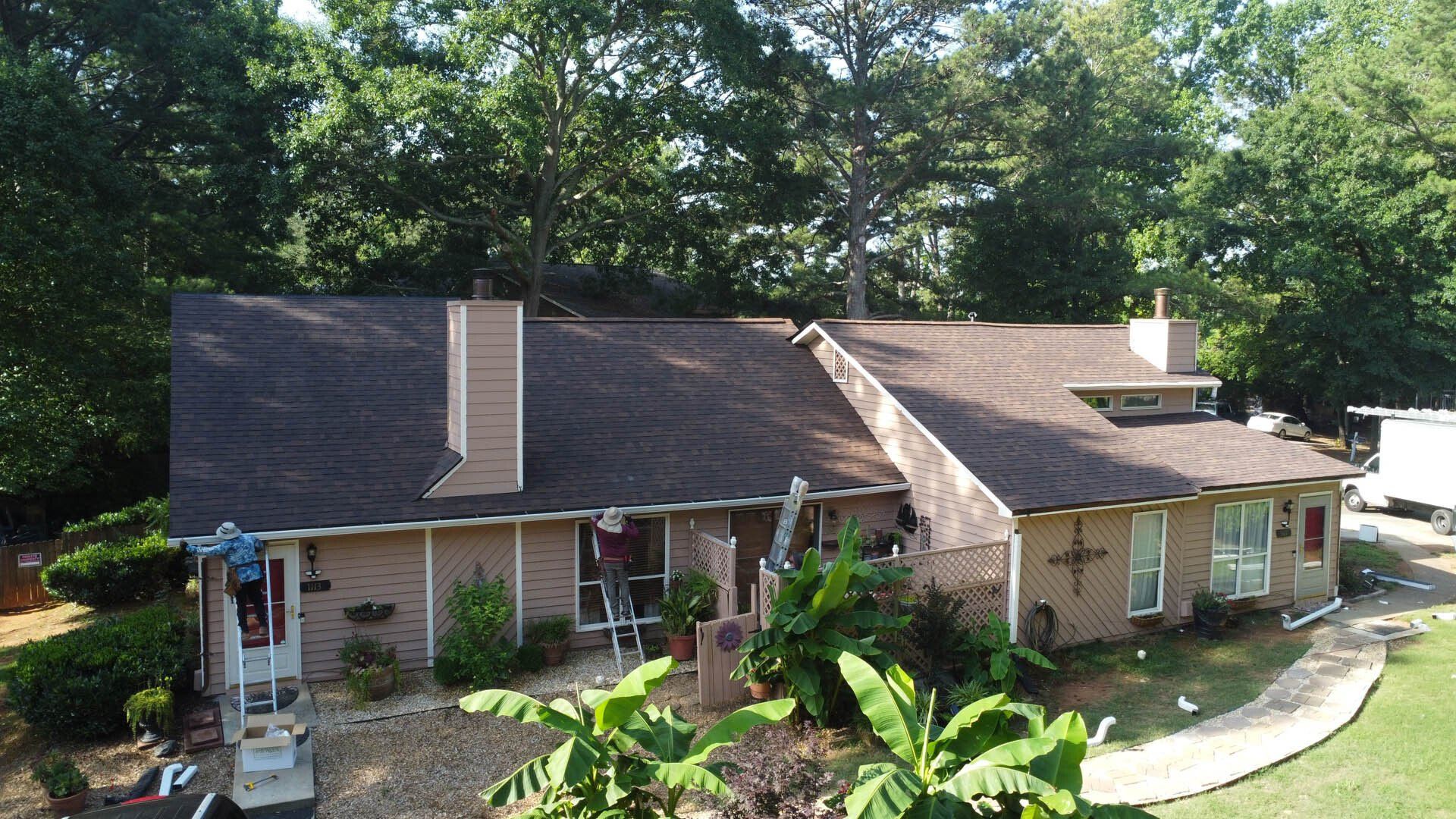 An aerial view of a brick house with a brown roof