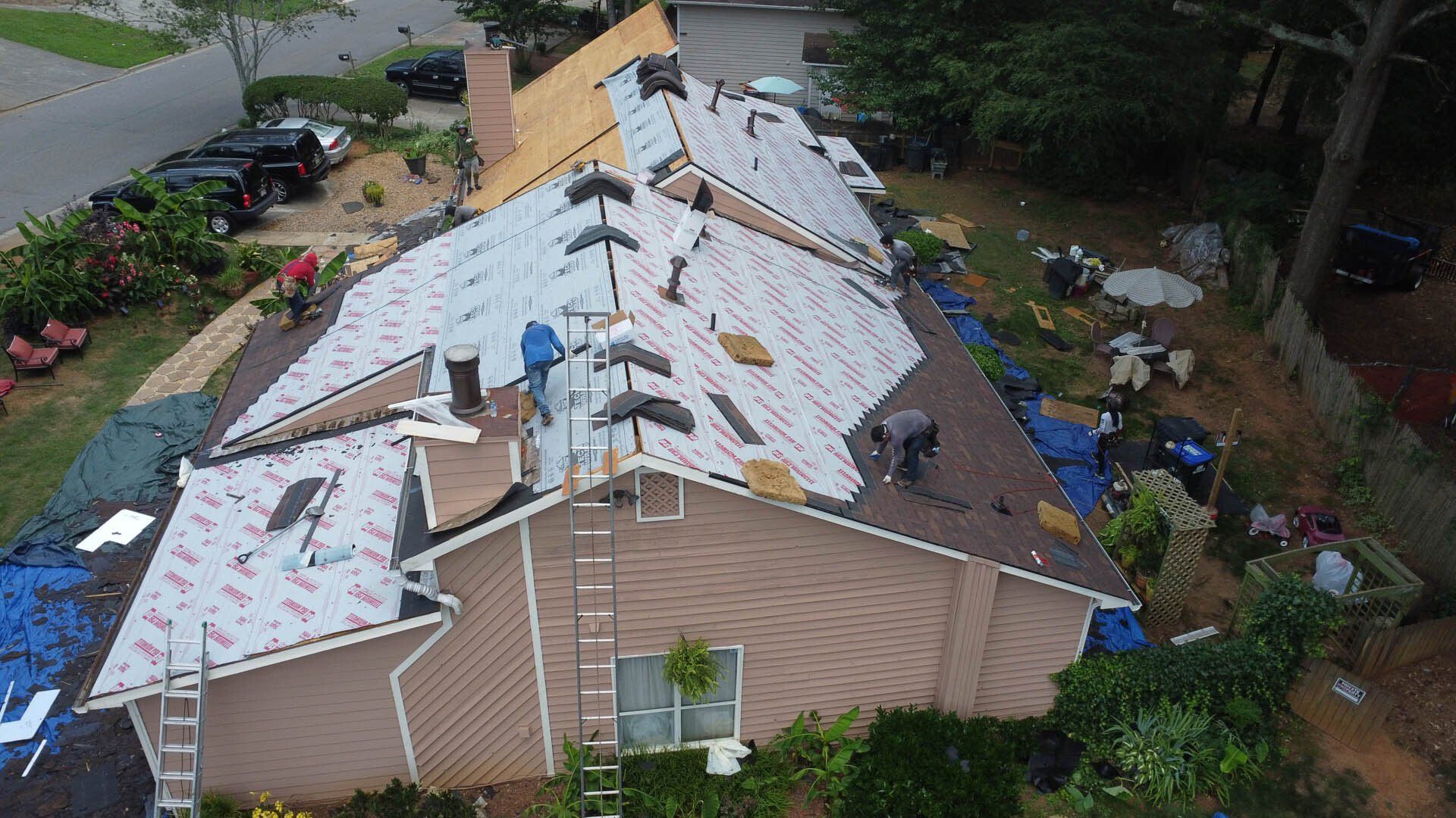 An aerial view of a house undergoing a roof replacement.