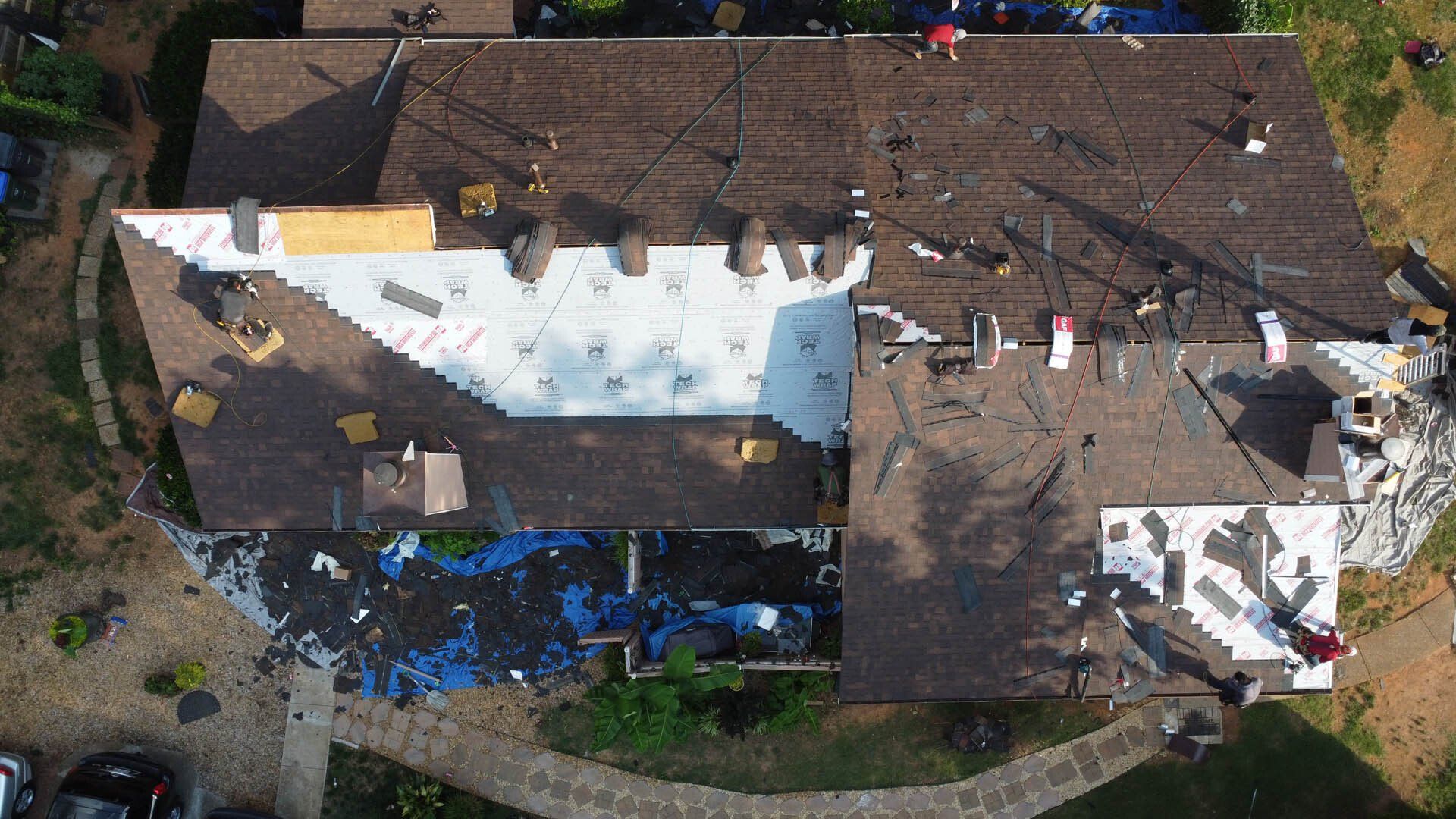 An aerial view of a house with a roof that is being repaired.