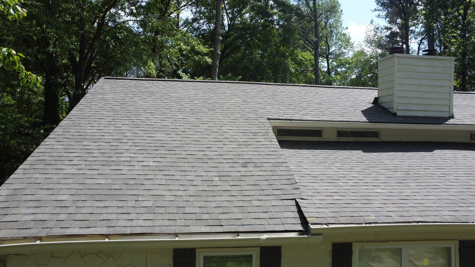 A roof of a house with a chimney on top of it.