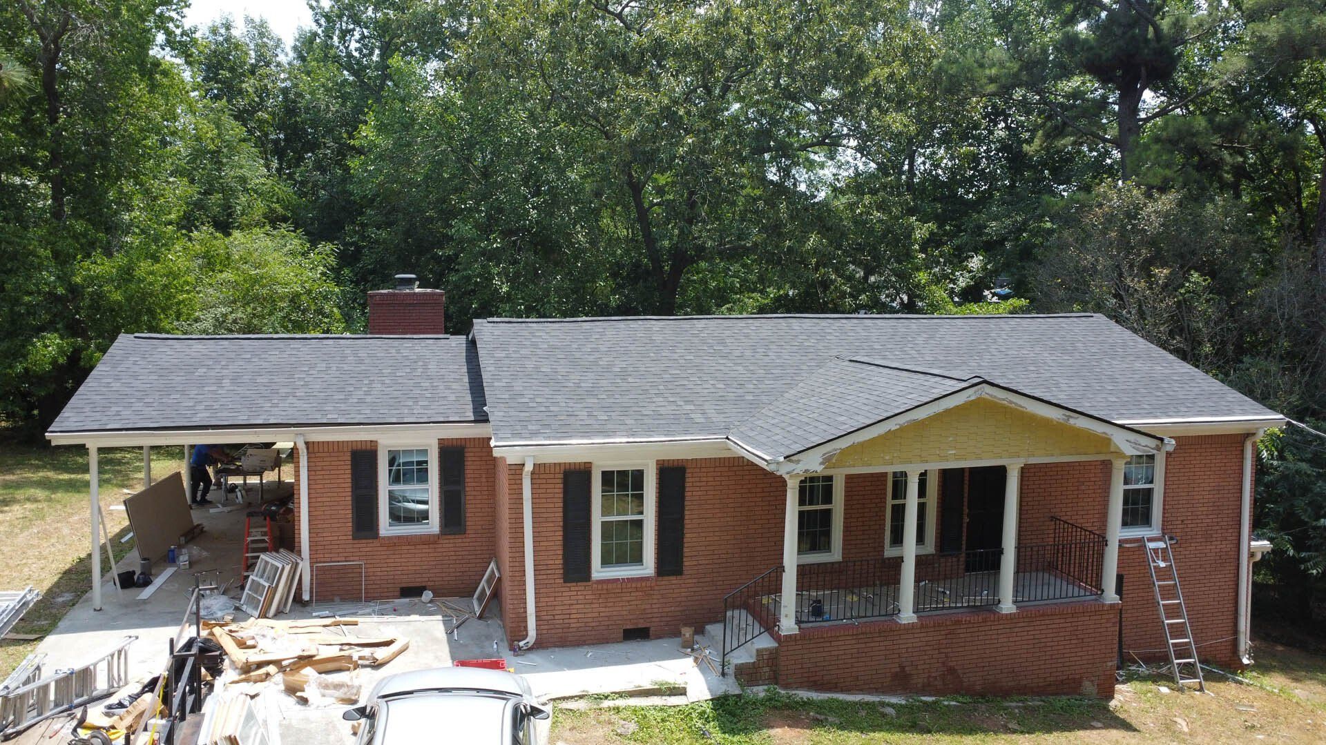 An aerial view of a brick house with a new roof.