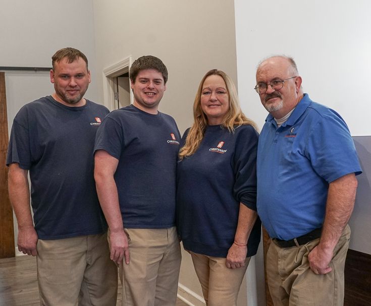 Three men and a woman are posing for a picture together