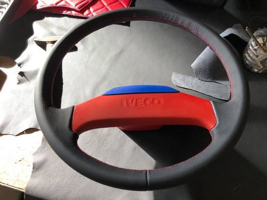 Un volante nero con il logo Iveco rosso sopra