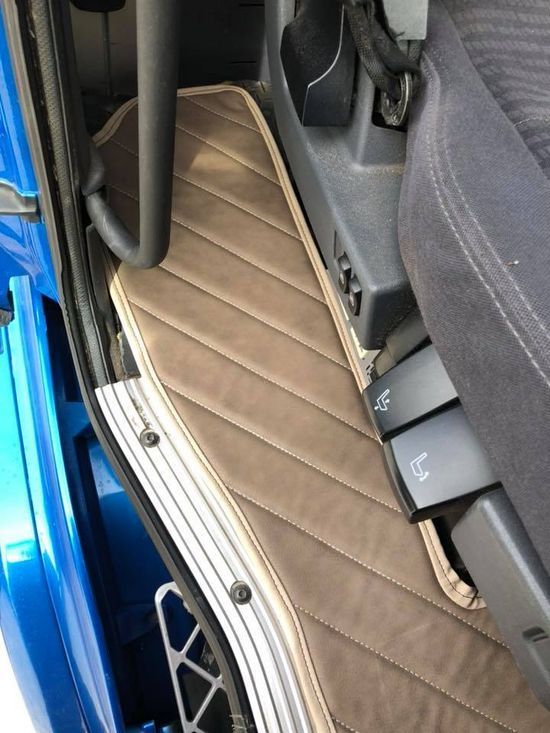 Un camion blu con un tappetino marrone sul pavimento
