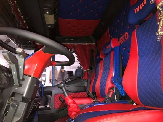 L'interno di un camion Iveco con sedili rossi e blu
