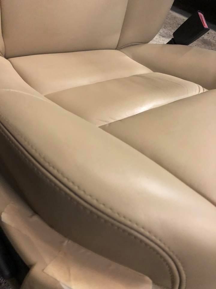 Primo piano di un sedile in pelle marrone chiaro di un'auto.
