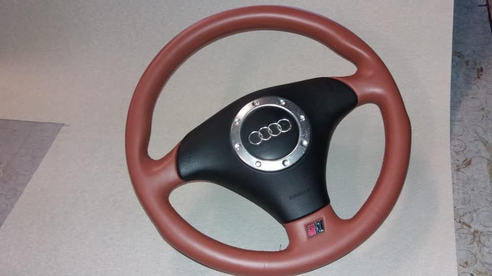 Un volante rosso e nero con il logo Audi su di esso