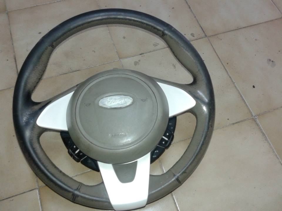 Un volante Ford poggia su un pavimento piastrellato