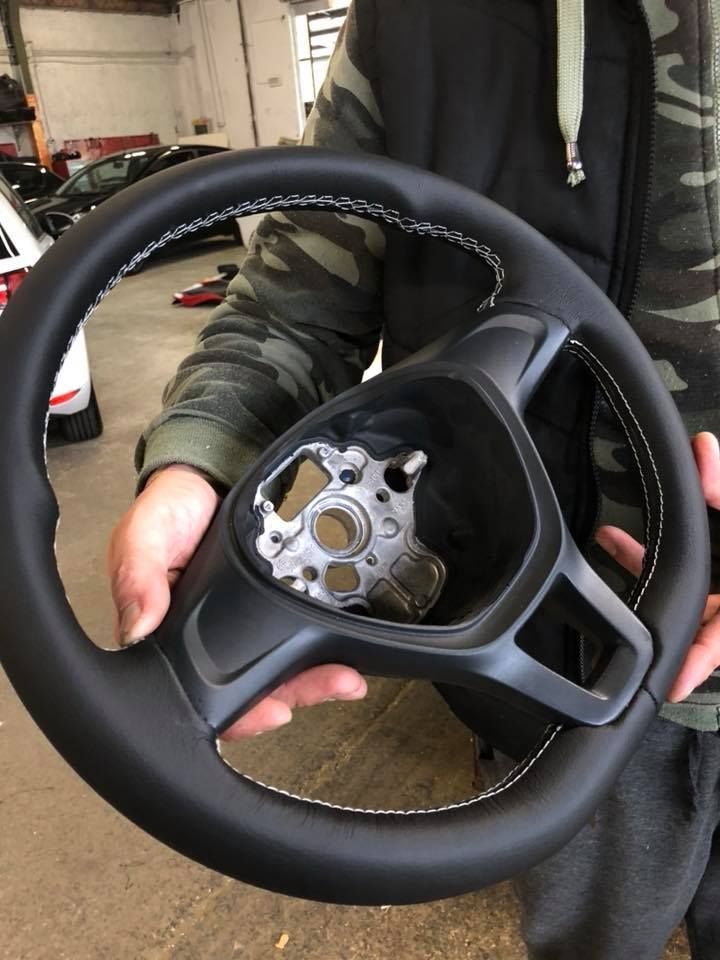 Una persona tiene in mano un volante nero.