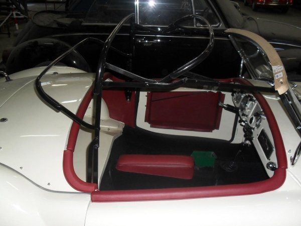 Un'auto bianca con sedile e volante rossi