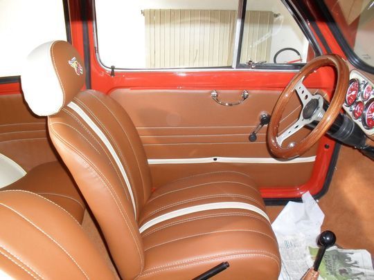 Un'auto rossa con sedili marroni e un volante