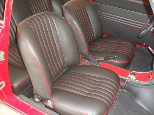 Un'auto rossa con sedili neri e finiture rosse