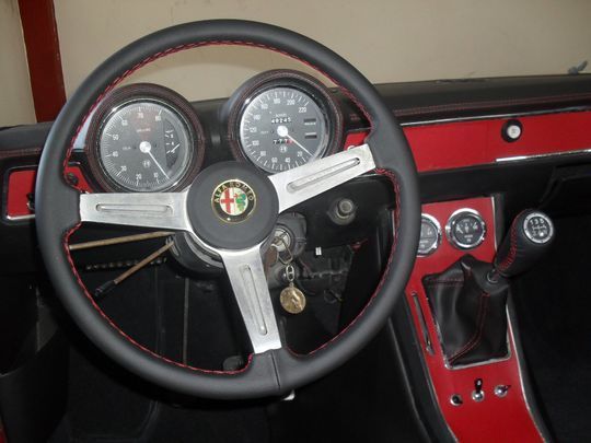Un volante nero e rosso con il logo Alfa Romeo sopra