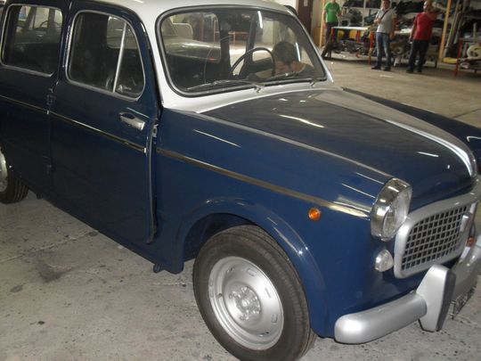 Un'auto blu e bianca è parcheggiata in un garage