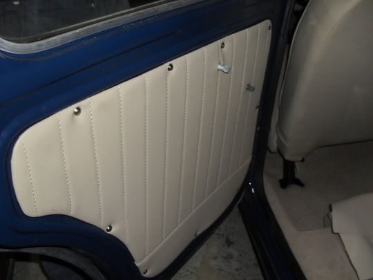 Un'auto blu con pannelli bianchi sulla portiera