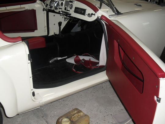 Un'auto bianca e rossa con la portiera aperta