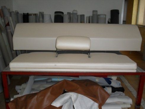 Un divano bianco è appoggiato su un tavolo rosso