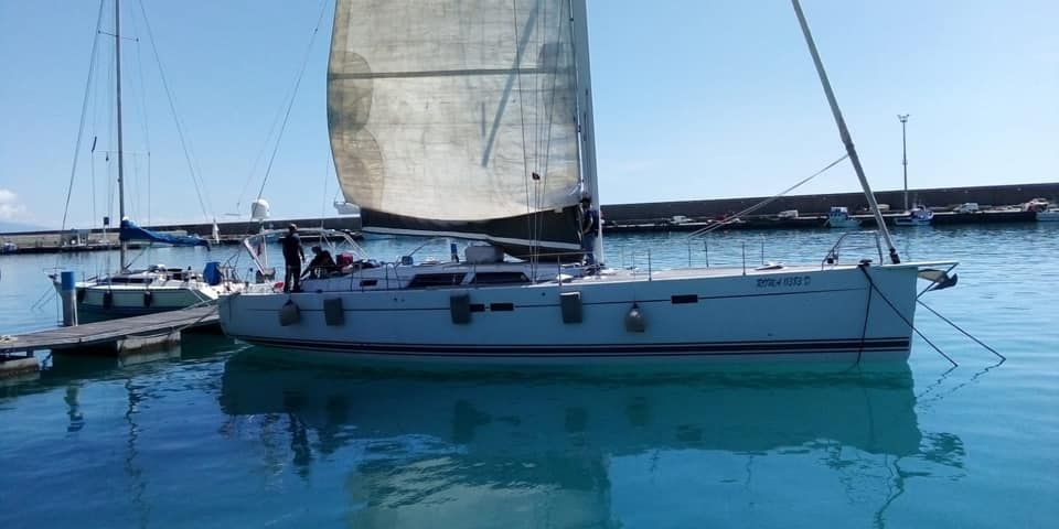 Una barca a vela è ormeggiata in un porto turistico in acqua.