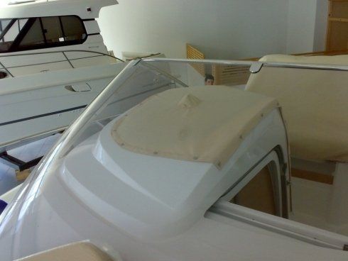Una barca bianca con un sedile marrone chiaro e un parabrezza trasparente