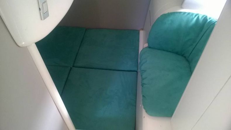 In una stanza c'è una sedia con dei cuscini verdi.