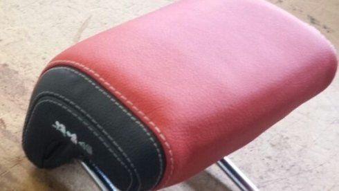 Un poggiatesta rosso e nero è appoggiato su un tavolo di legno.