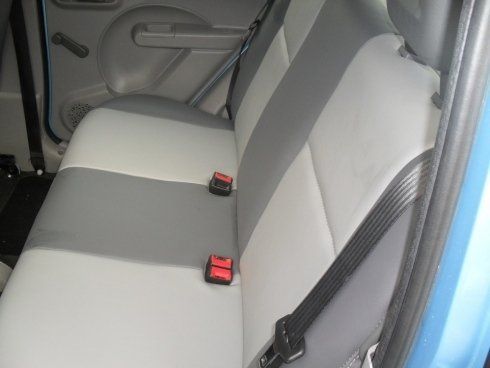 Il sedile posteriore di un'auto blu con cintura di sicurezza.