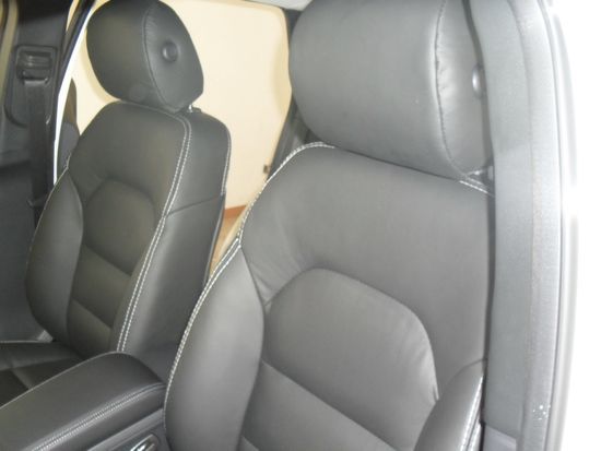 Due sedili in pelle nera in un'auto con cuciture bianche