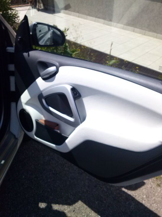 Un'auto bianca e nera con la portiera aperta