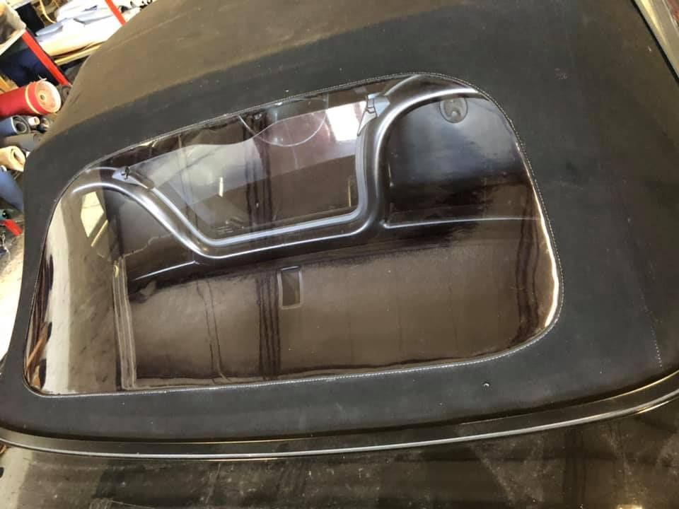 Un'auto nera con capote è parcheggiata in un garage.