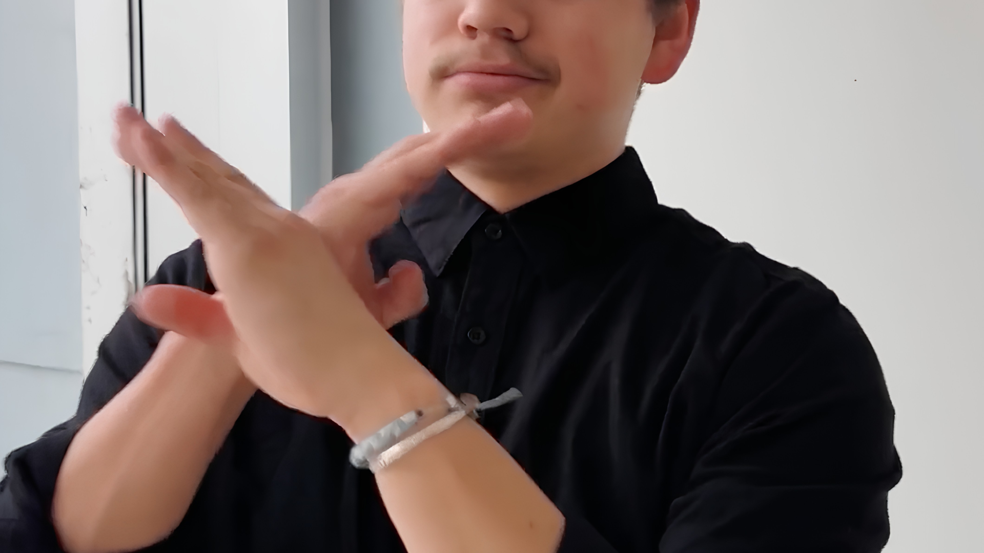 A person wearing a black shirt signs 