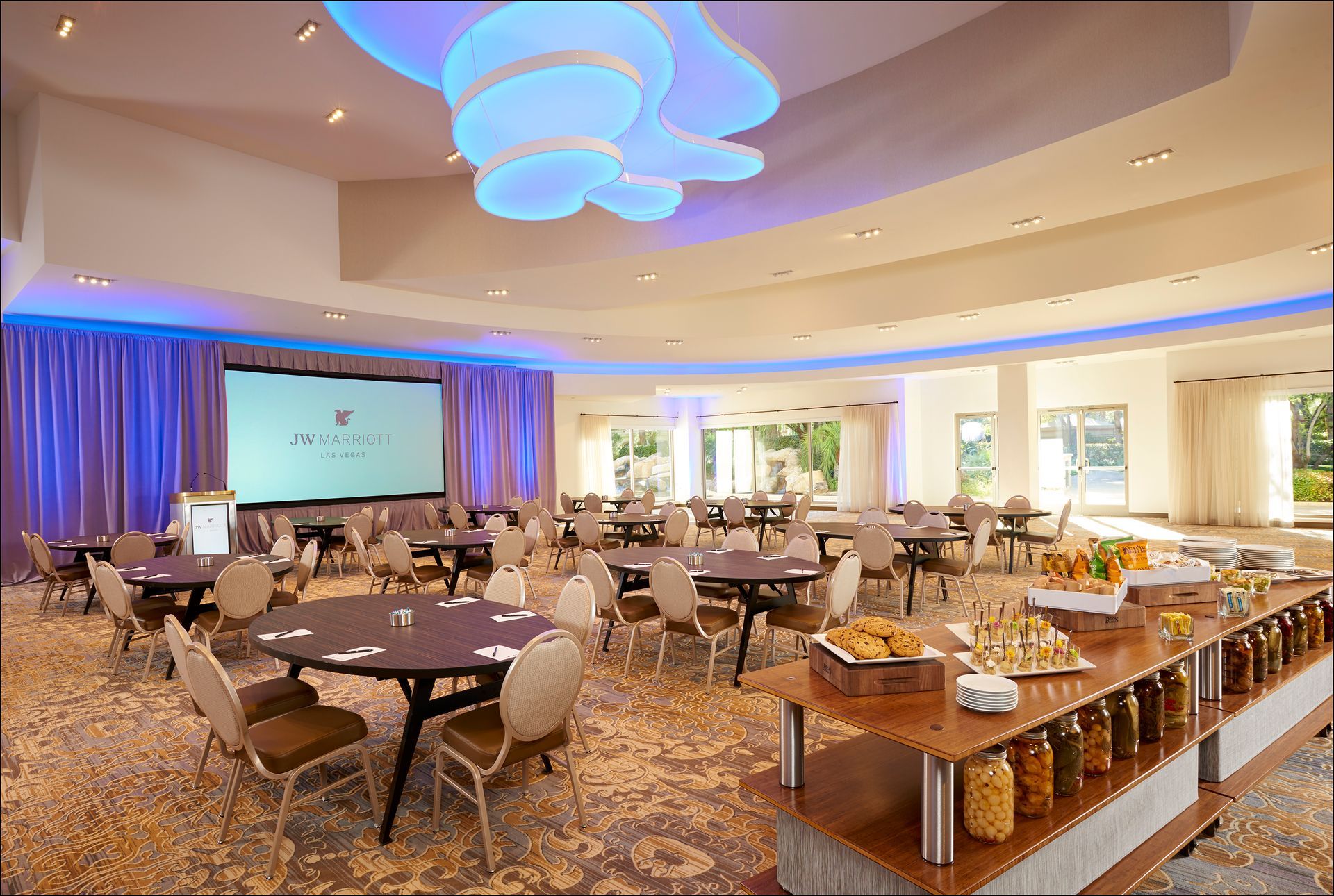 A large room with tables and chairs and a buffet table.
