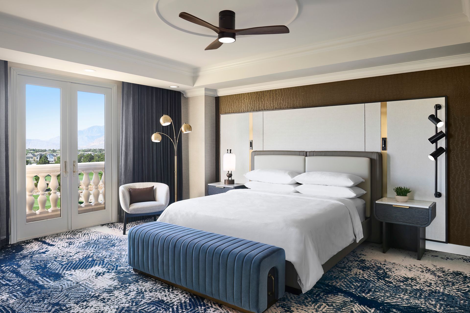 A hotel room with a large bed and a ceiling fan.