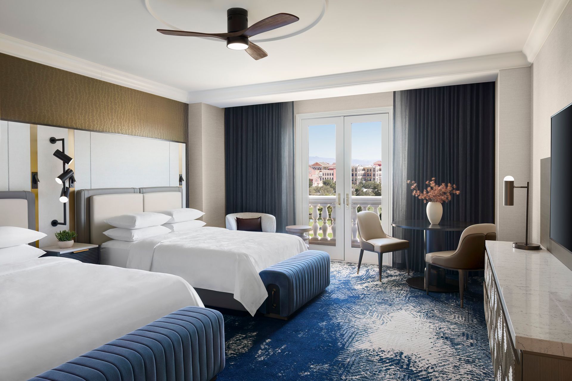 Hotel room with two beds, a balcony, and a dark blue and white rug.