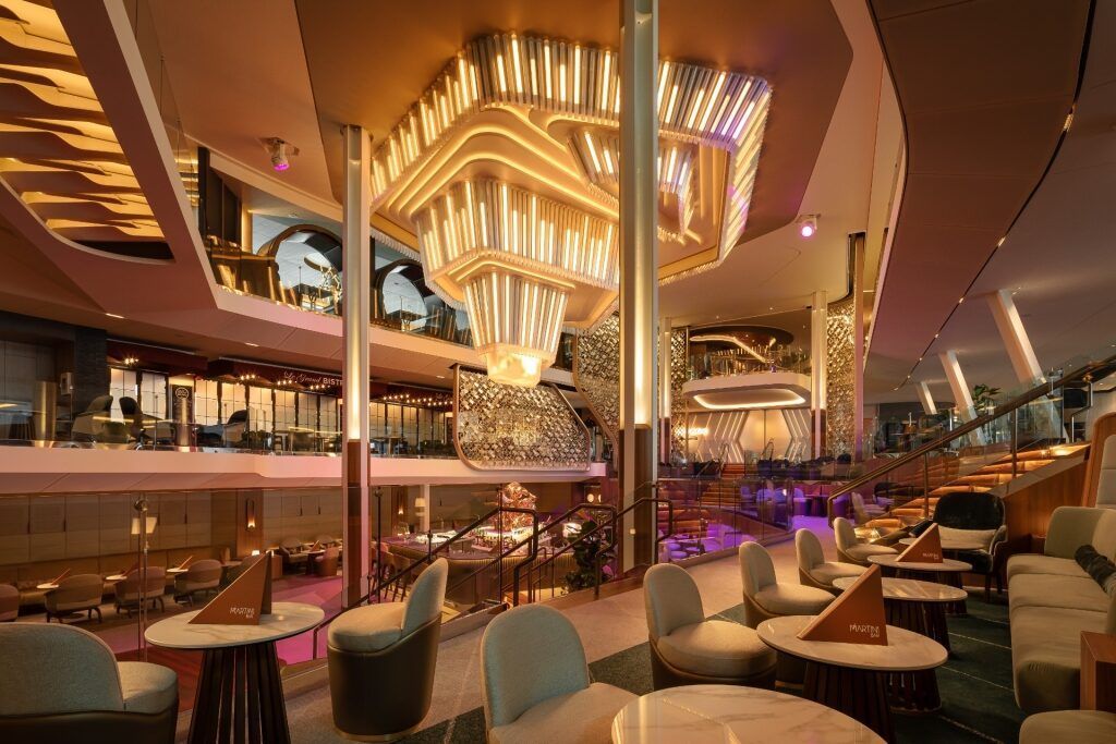 A large room with tables and chairs and a chandelier hanging from the ceiling.