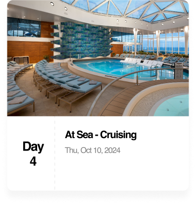 Indoor cruise ship pool area with lounge chairs, jacuzzi, and ocean view.