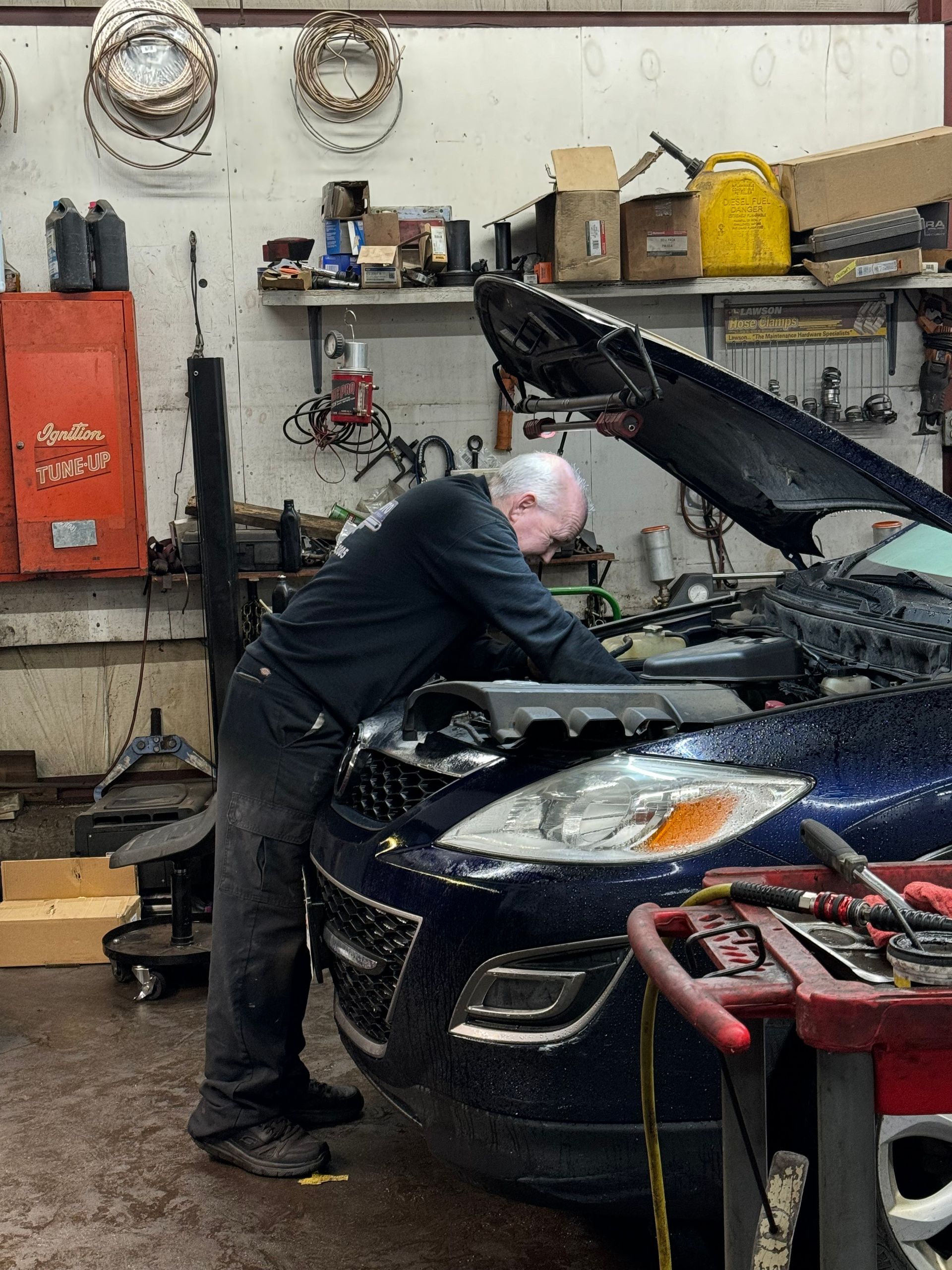 Mechanic works on a blue car engine | Keegan Auto