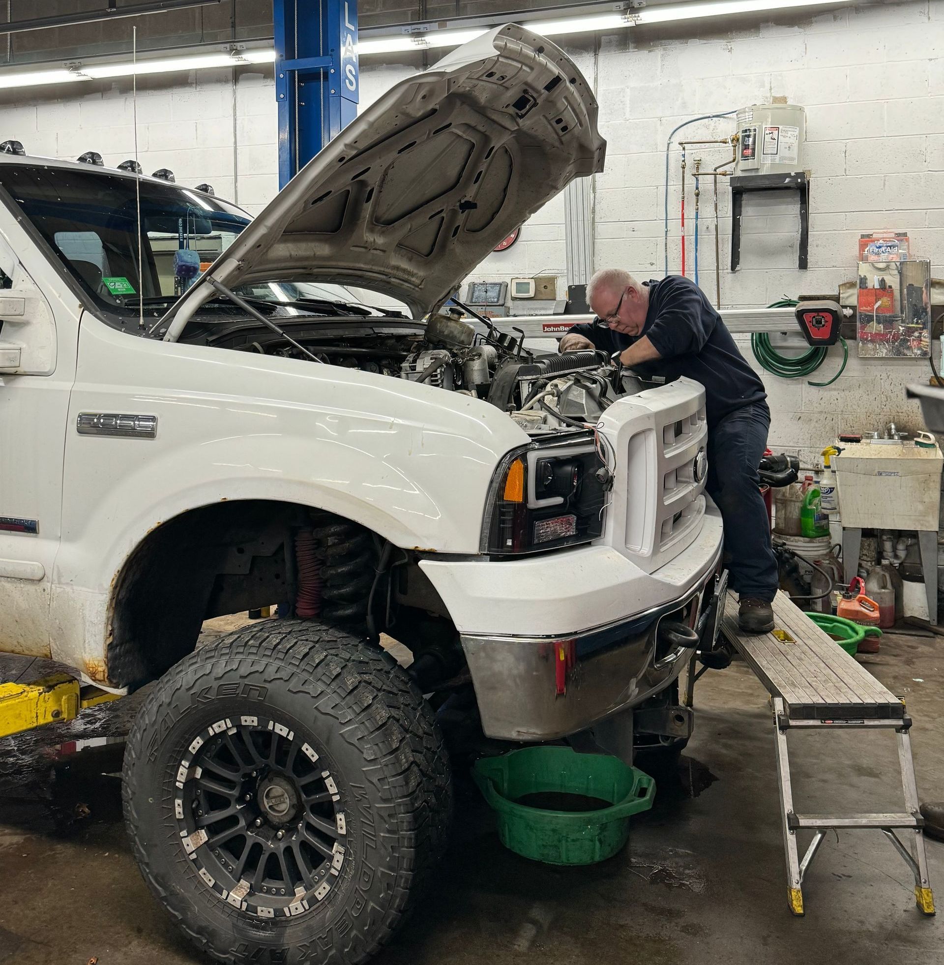 Mechanic working on a white Ford truck | Keegan Auto