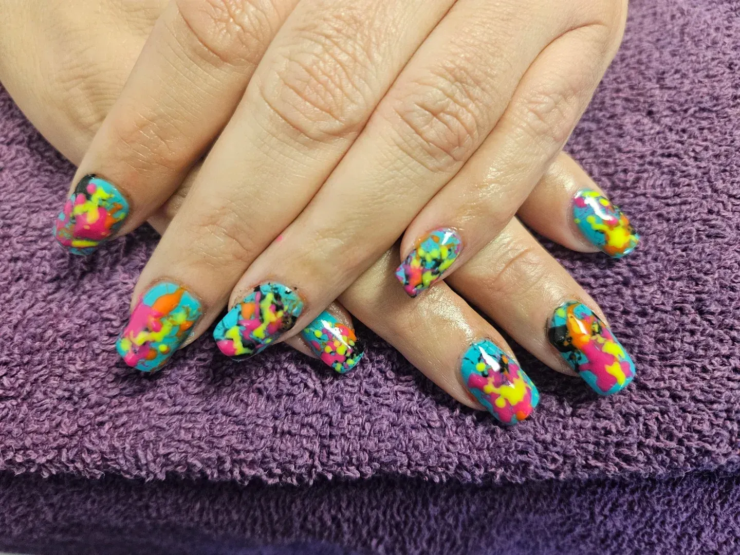 A close up of a woman 's nails on a purple towel