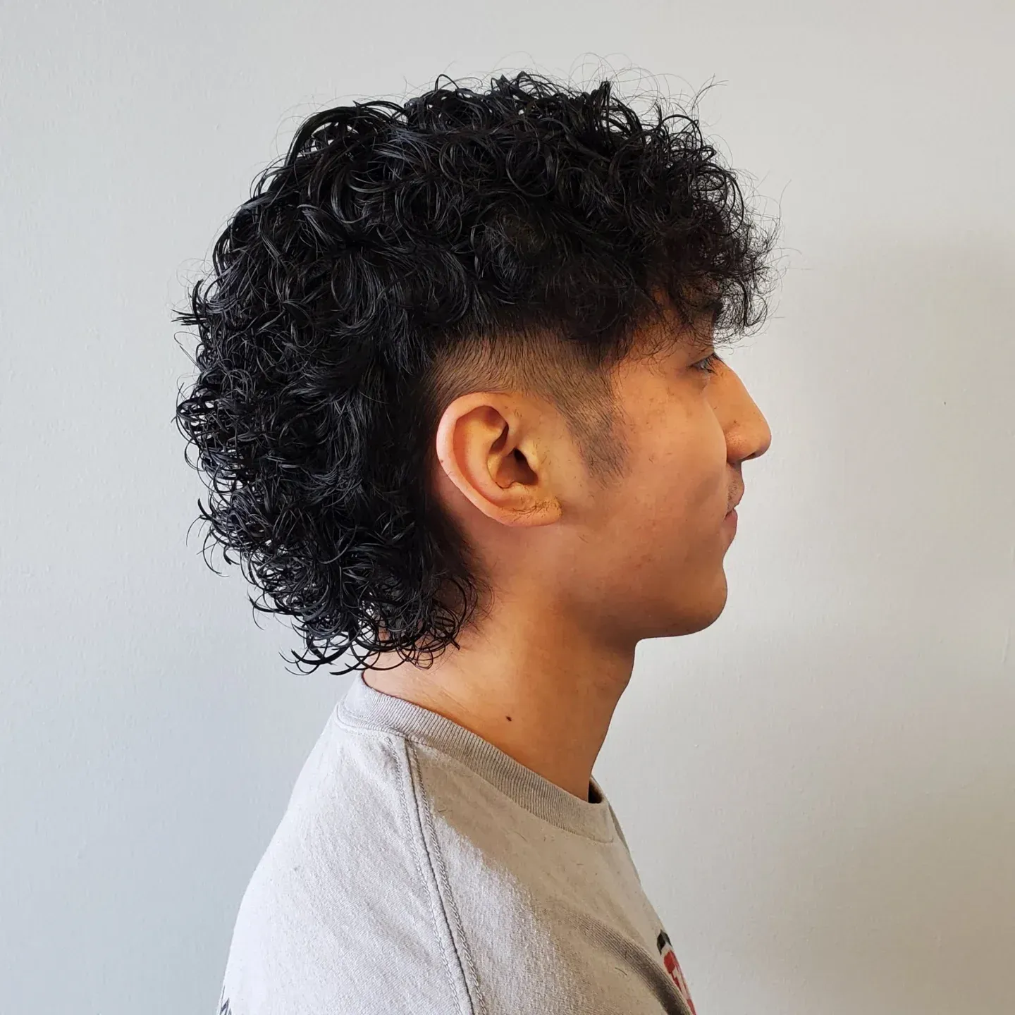 A woman is getting her hair cut by a hairdresser with scissors.