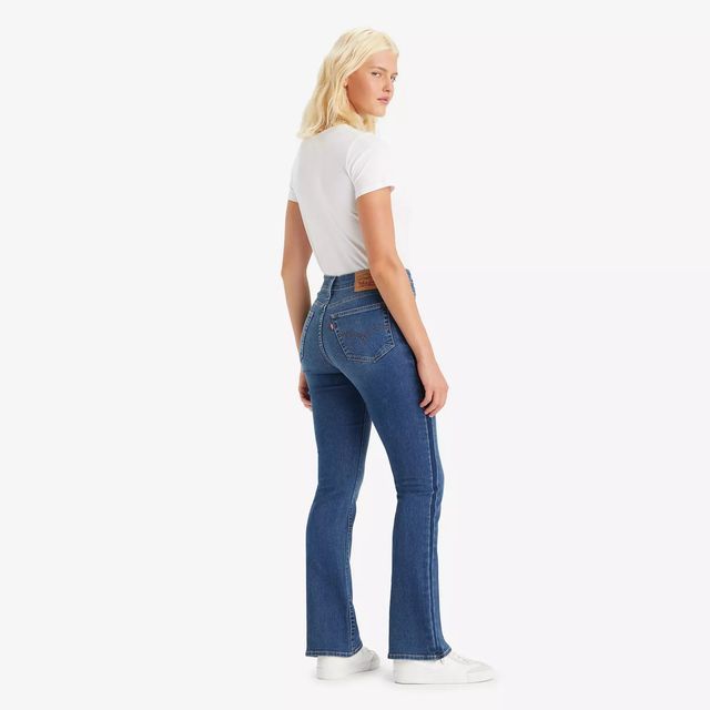 Una donna indossa una maglietta bianca e jeans blu.