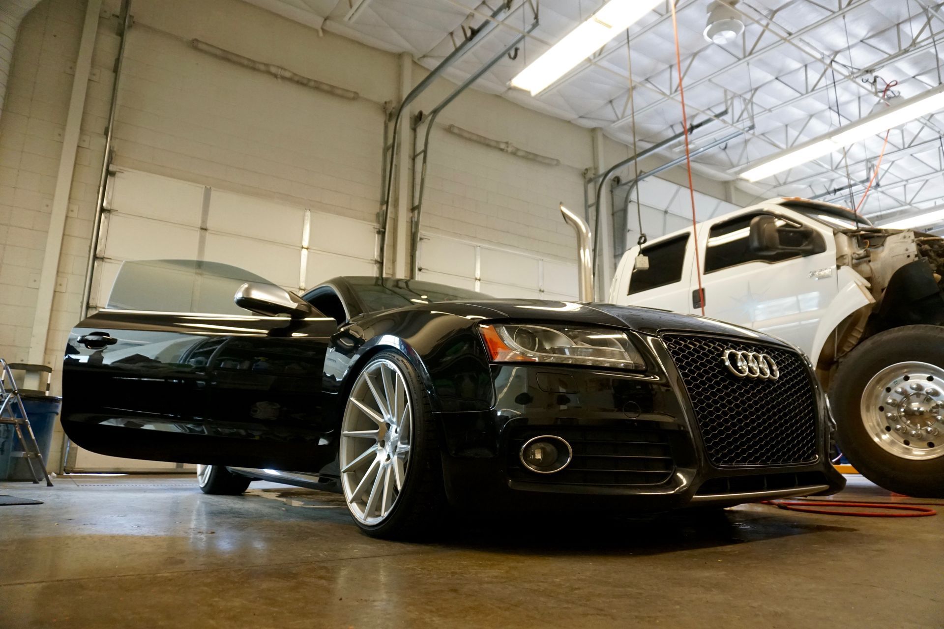 Black Audi Parked Inside Garage for Service or Display | Auto Repair & Used Car Sales